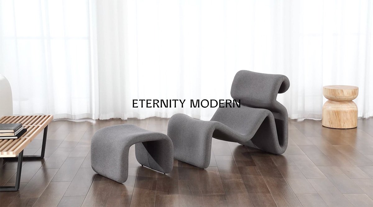 Close-up of the back of a grey upholstered lounge chair showing rounded headrest and adjacent ottoman