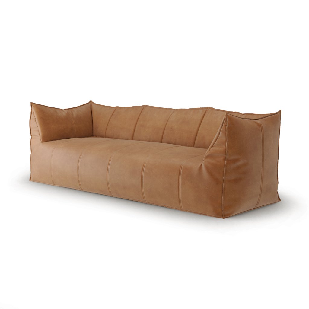 Side angle of the tan leather sofa showing the back cushions and soft padding.