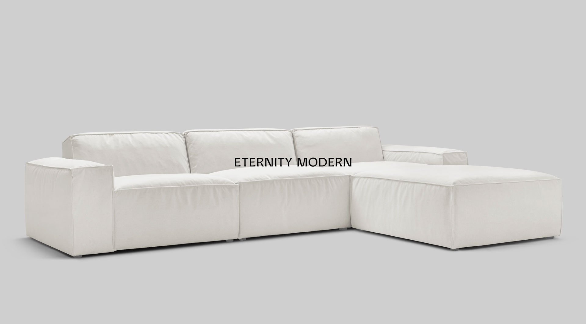 White modular sofa with chaise section forming an L-shape.