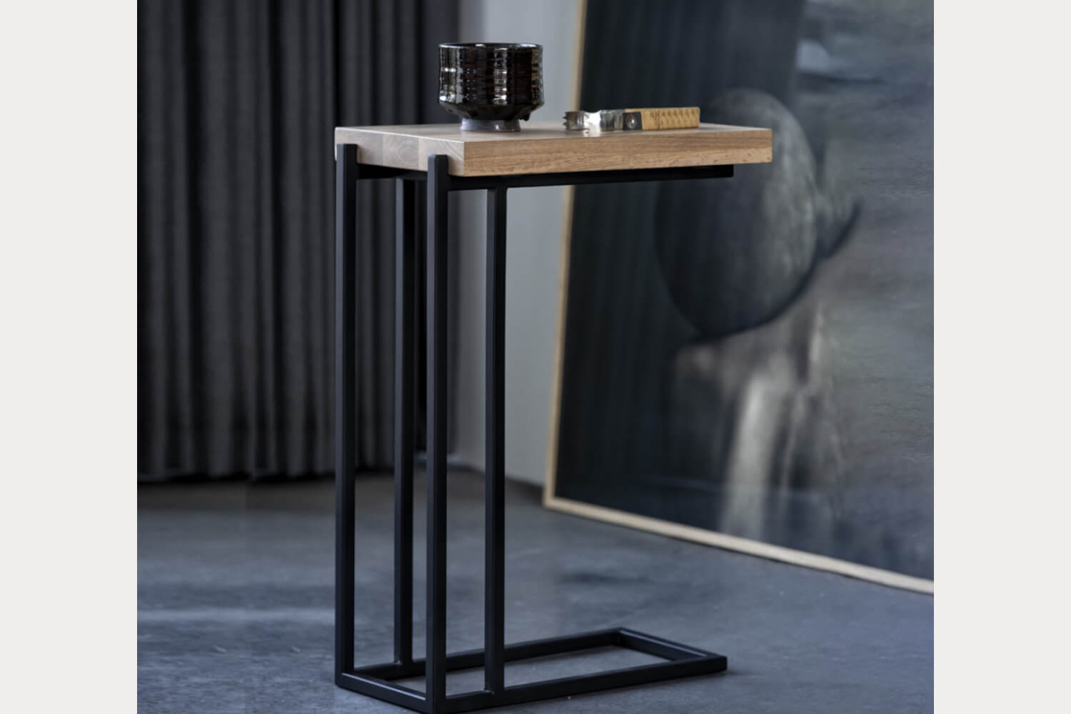 Luka Oak Wood Side Table with a slender black metal frame supporting a simple oak wood top.