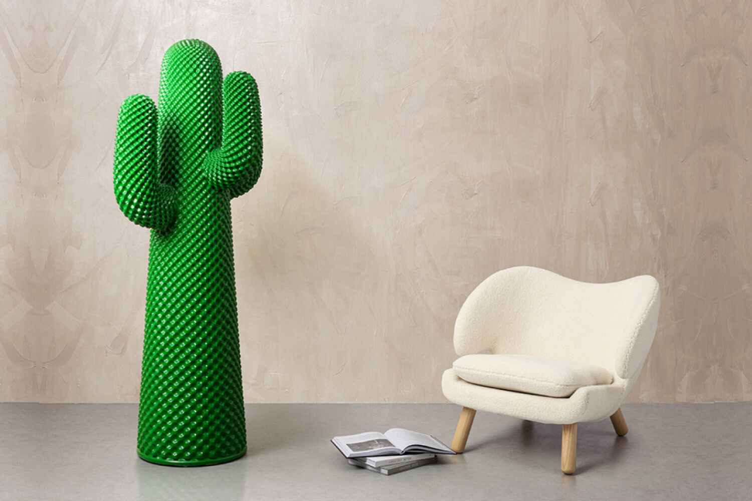 A room featuring the Drocco & Mello Sculptural Cactus Coat Rack, a vibrant green, cactus-shaped piece with a textured surface, and the Finn Juhl Pelican Chair. 