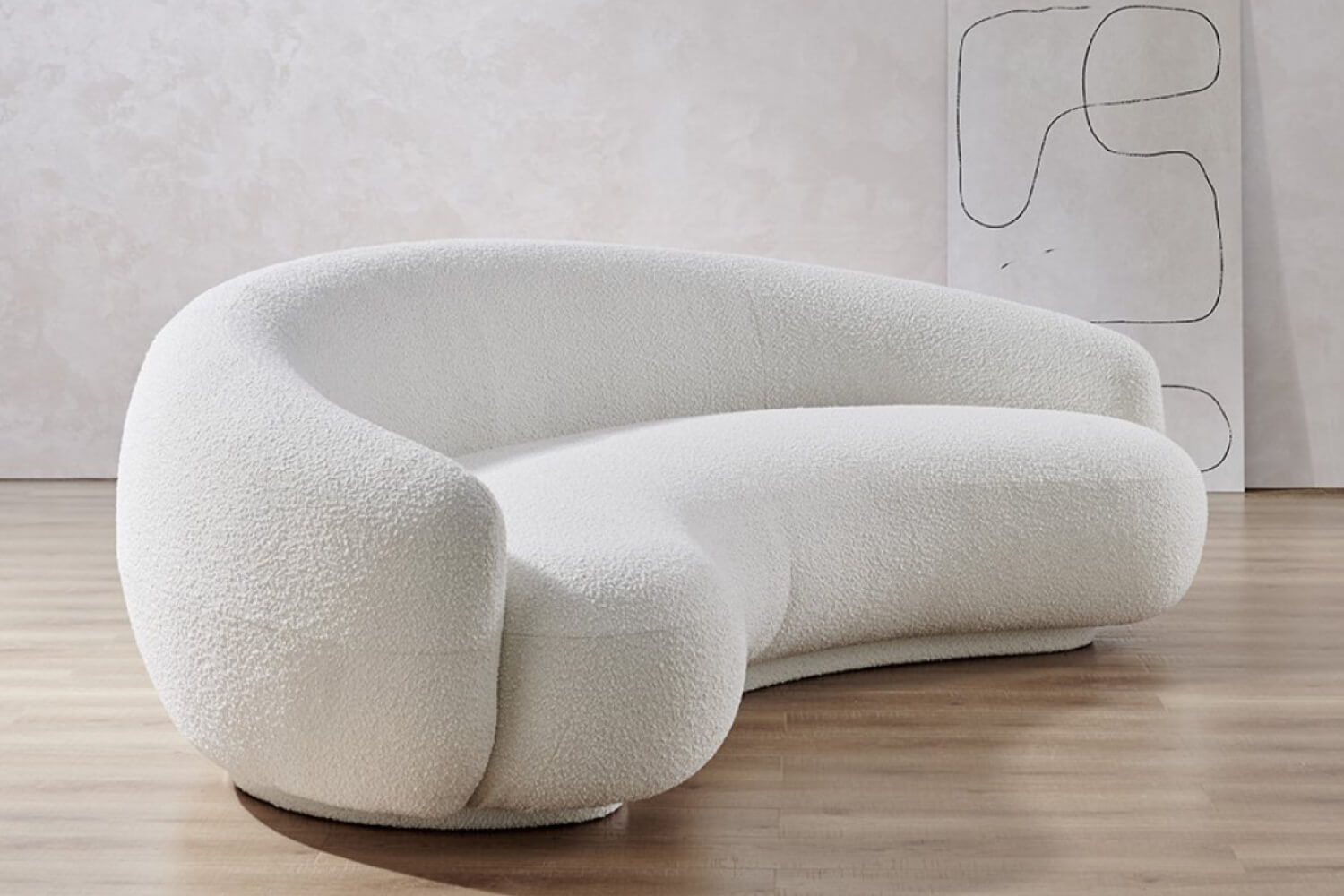 A Savelle Modern Curved Sofa with a white fabric featuring a flowing, organic shape that creates an inviting and plush seating area, set in a room with a light wooden floor and abstract wall art.