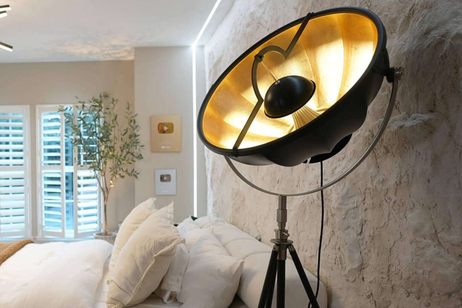 Modern Floor Lamp with a golden interior shade standing in a cozy bedroom. 