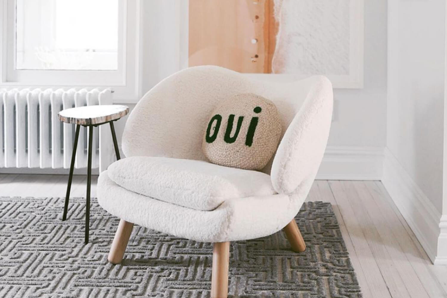 A cozy and plush white Finn Juhl Pelican Chair in the living room. 